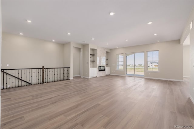 56159 E Tomahawk Ave, Strasburg, CO 80136 - unfurnished living room featuring light wood-style flooring, recessed lighting, and baseboards