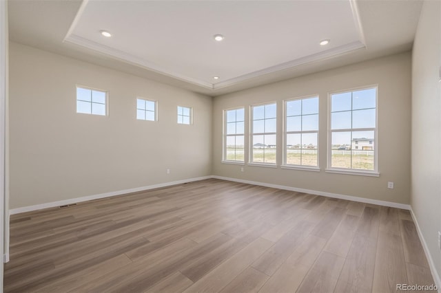 56159 E Tomahawk Ave, Strasburg, CO 80136 - spare room with a tray ceiling, light wood finished floors, baseboards, and recessed lighting