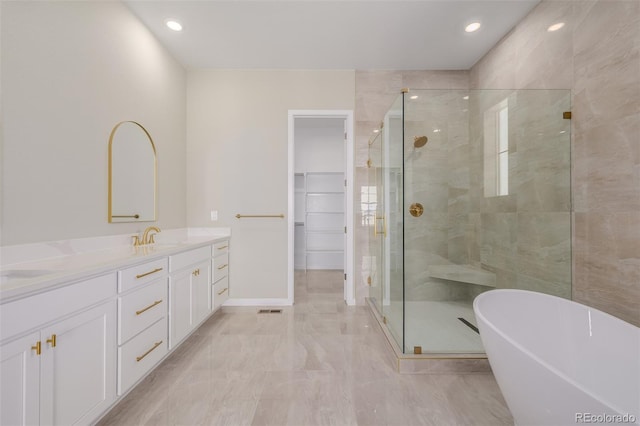 56159 E Tomahawk Ave, Strasburg, CO 80136 - bathroom with a shower stall, double vanity, a freestanding bath, a spacious closet, and recessed lighting