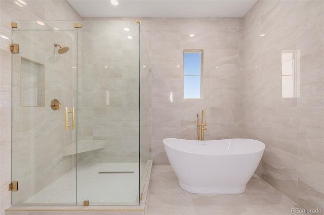 56159 E Tomahawk Ave, Strasburg, CO 80136 - bathroom featuring a freestanding bath, a shower stall, and tile walls