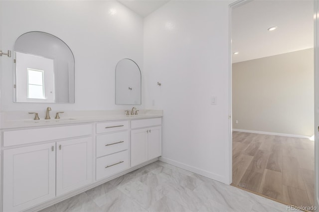 56159 E Tomahawk Ave, Strasburg, CO 80136 - bathroom with baseboards, double vanity, and marble finish flooring