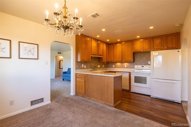 971 Elm Pl, Thornton, CO 80229 - kitchen featuring white appliances, arched walkways, light countertops, a peninsula, and a chandelier