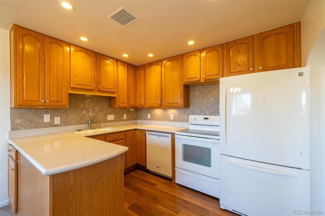 971 Elm Pl, Thornton, CO 80229 - kitchen with white appliances, a sink, a peninsula, light countertops, and dark wood-style floors
