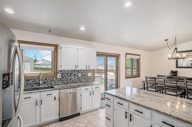 kitchen featuring appliances with stainless steel finishes, tasteful backsplash, light tile patterned floors, and plenty of natural light