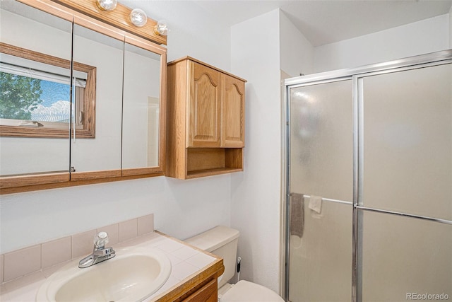 bathroom with vanity, toilet, and a shower with door