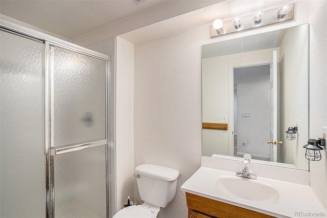 bathroom with vanity, an enclosed shower, and toilet