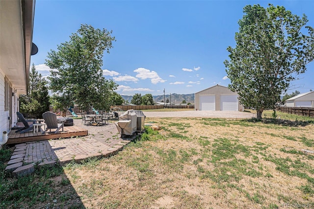 view of yard with a garage, an outdoor structure, and a deck