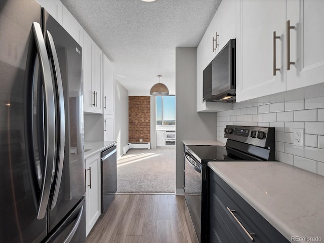 850 20th St Unit 503, Boulder, CO 80302 - kitchen featuring stainless steel appliances, wood finished floors, a baseboard radiator, light countertops, and a textured ceiling