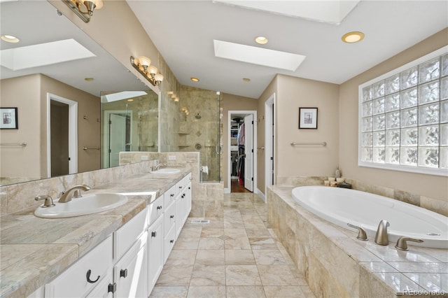 520 Jackson St, Denver, CO 80206 - bathroom featuring a sink, marble finish floor, a shower stall, a skylight, and a garden tub