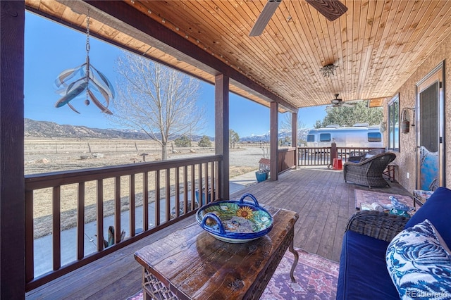 wooden deck featuring a mountain view and ceiling fan