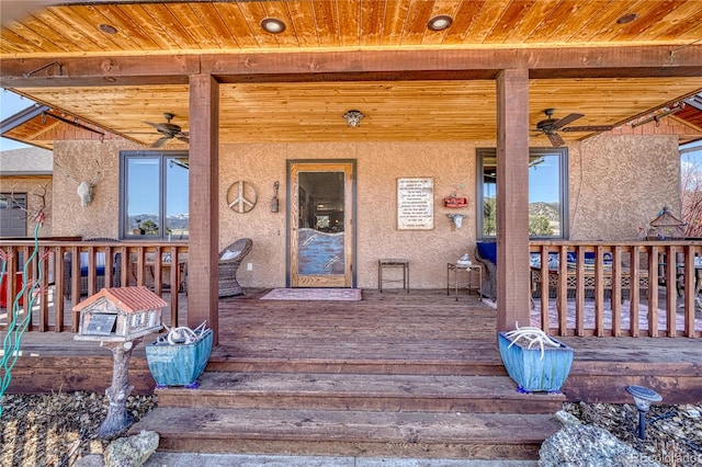 entrance to property featuring a deck and ceiling fan