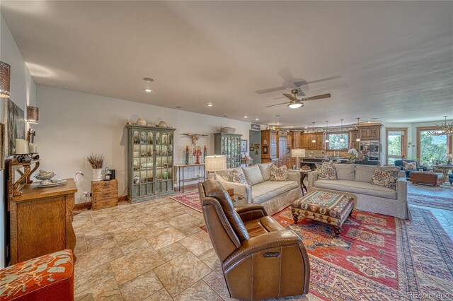 living room with ceiling fan with notable chandelier