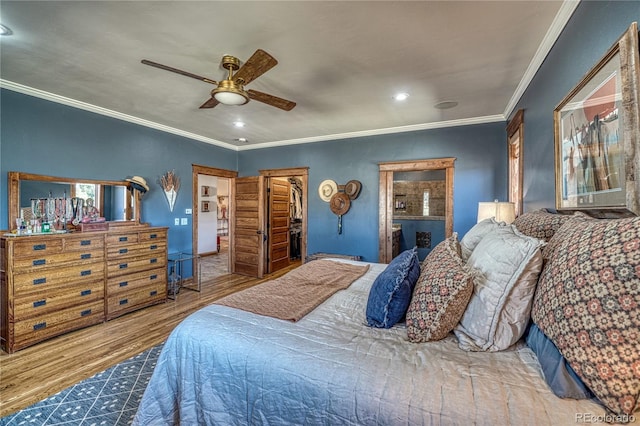 bedroom with ceiling fan, hardwood / wood-style floors, ornamental molding, a spacious closet, and a closet