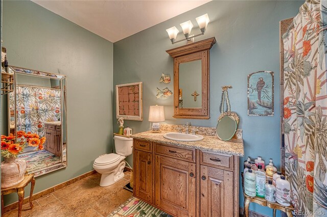 bathroom featuring tile floors, toilet, and vanity