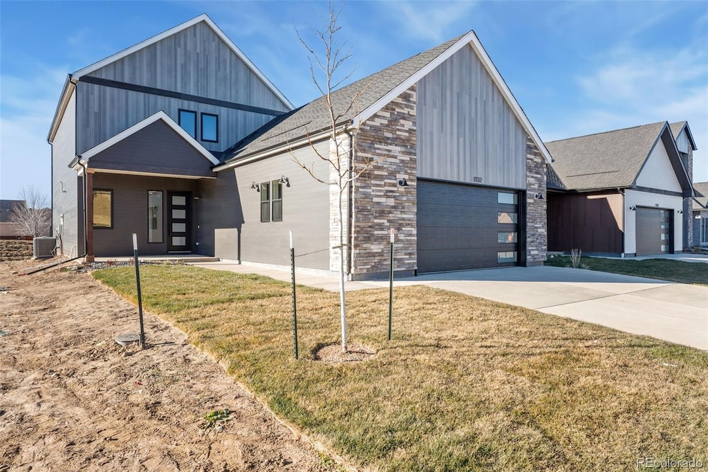 view of front of home with a garage, a front lawn, and central air condition unit