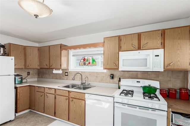 kitchen featuring tasteful backsplash, sink, and white appliances