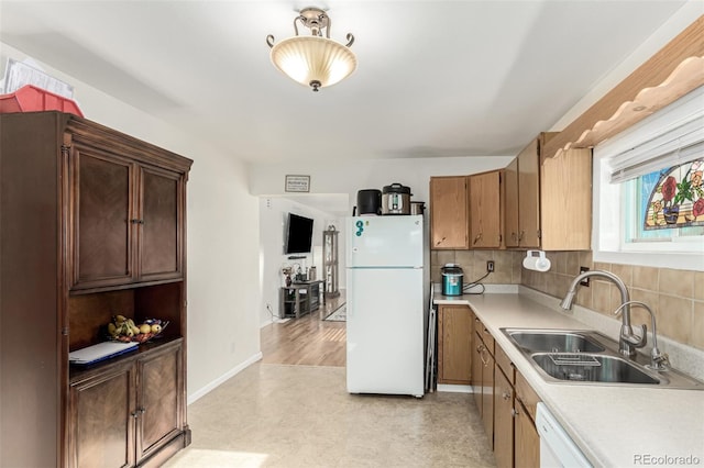 kitchen with tasteful backsplash, white appliances, and sink