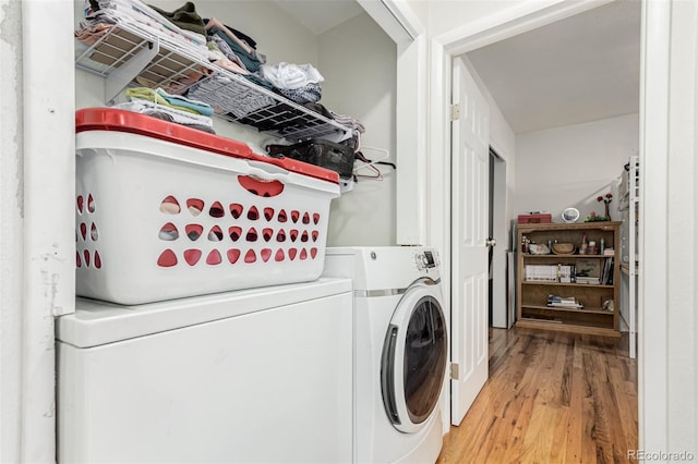 washroom with hardwood / wood-style flooring and washer and dryer