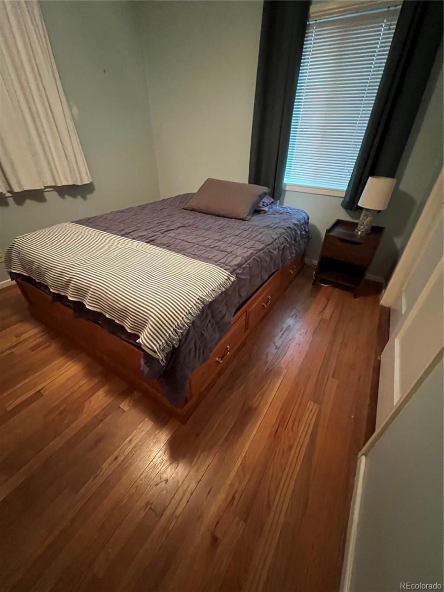 bedroom with wood finished floors and baseboards