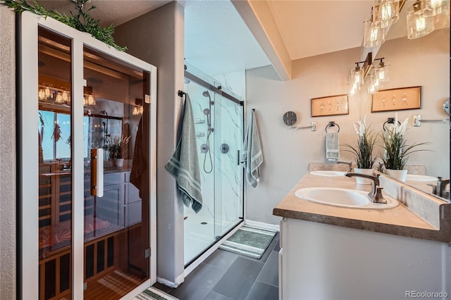 bathroom featuring a shower with door and vanity