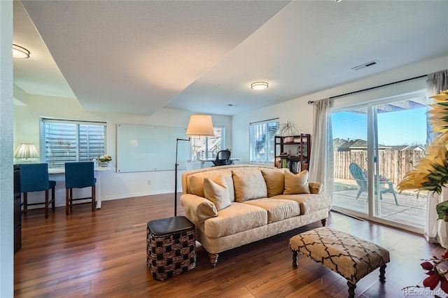 living room with a healthy amount of sunlight and dark hardwood / wood-style flooring