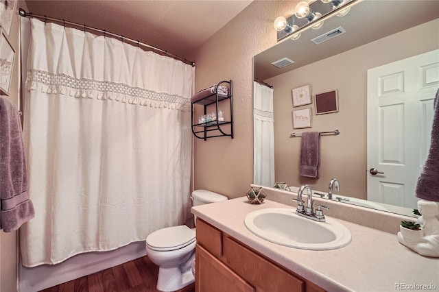 full bathroom with a textured ceiling, shower / tub combo, toilet, wood-type flooring, and vanity