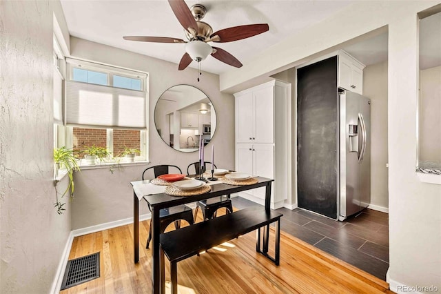 dining room with wood finished floors, visible vents, and baseboards