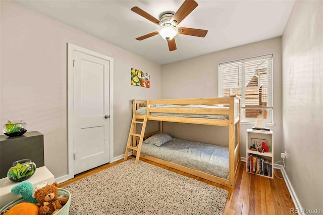 bedroom with a ceiling fan, baseboards, and hardwood / wood-style floors