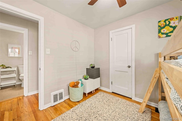 bedroom featuring baseboards, visible vents, ceiling fan, and light wood finished floors