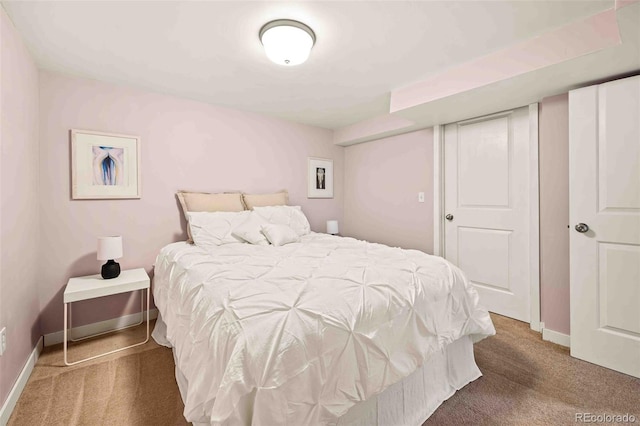 bedroom with a closet, baseboards, and carpet flooring