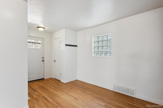 foyer entrance featuring light wood finished floors, baseboards, and visible vents