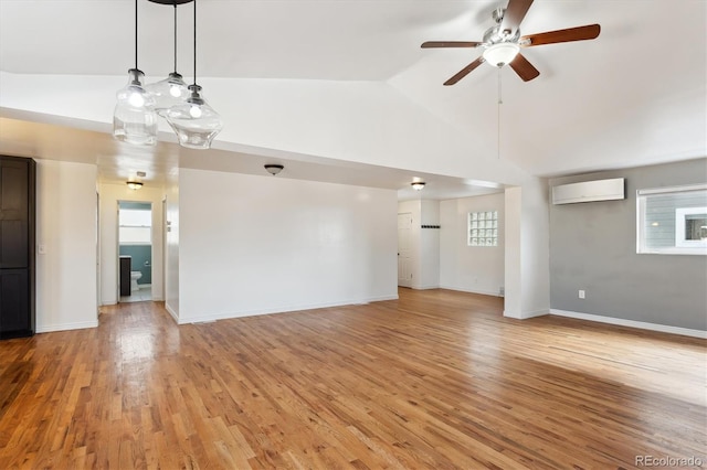 unfurnished living room featuring high vaulted ceiling, a wall unit AC, light hardwood / wood-style floors, and ceiling fan