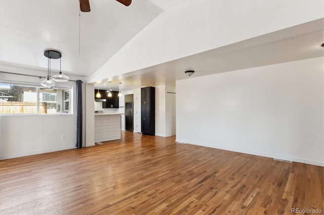 unfurnished living room featuring hardwood / wood-style flooring, ceiling fan, and high vaulted ceiling