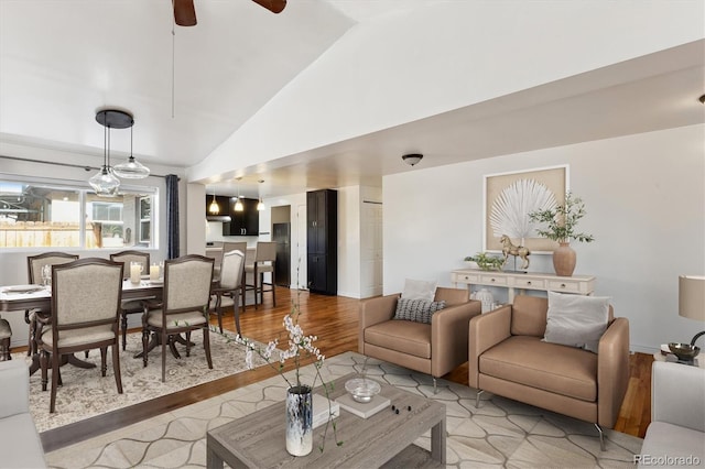 living room featuring vaulted ceiling, ceiling fan, and light wood-type flooring