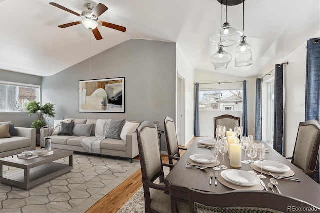 dining area with ceiling fan, lofted ceiling, and light wood-type flooring