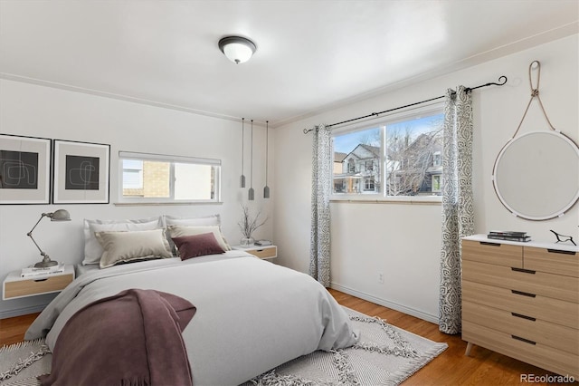 bedroom with baseboards and wood finished floors