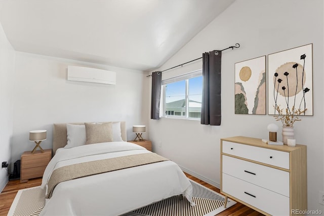 bedroom featuring hardwood / wood-style flooring, vaulted ceiling, and a wall unit AC