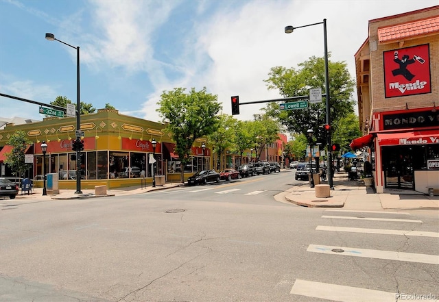 view of street with street lighting, traffic lights, curbs, and sidewalks