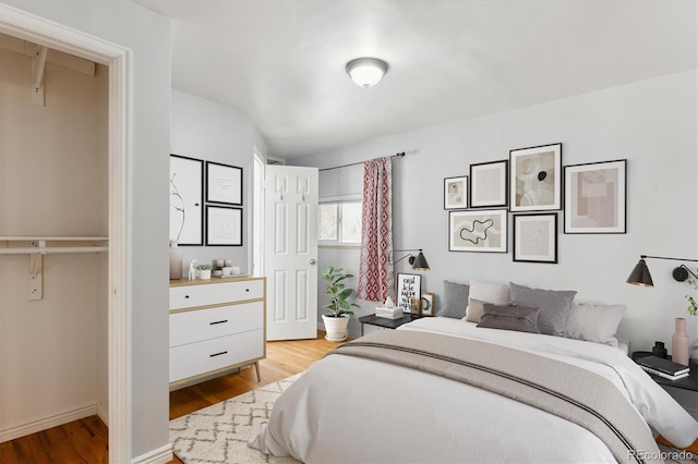 bedroom with wood finished floors and baseboards