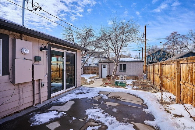 yard layered in snow with fence and an outdoor structure