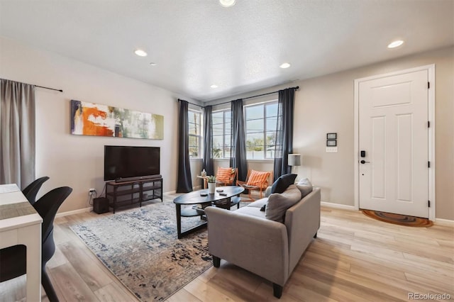 living area with light wood-style flooring, baseboards, and recessed lighting