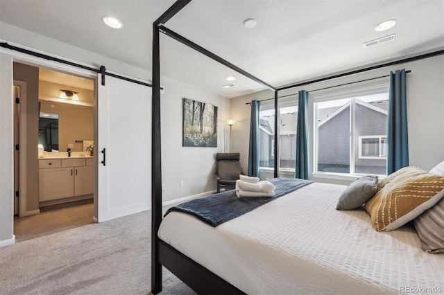 bedroom with a barn door, carpet, baseboards, connected bathroom, and recessed lighting