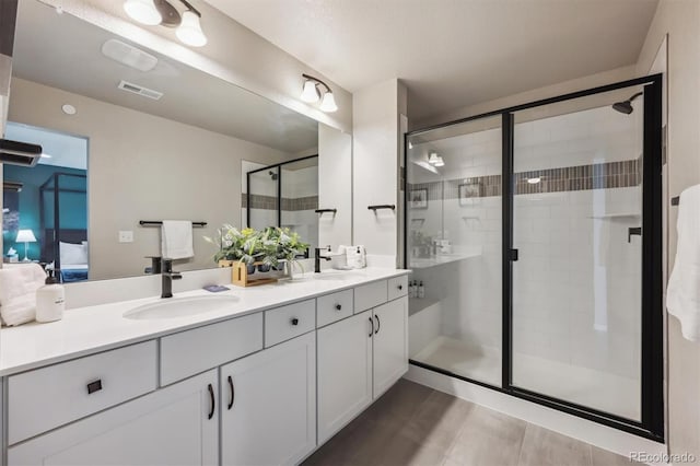 ensuite bathroom featuring a stall shower and double vanity