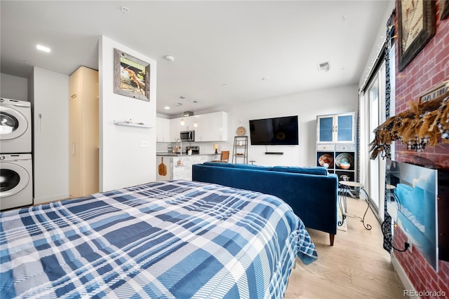 1898 S Bannock St Unit 202, Denver, CO 80223 - bedroom with stacked washer and clothes dryer and light wood-style floors
