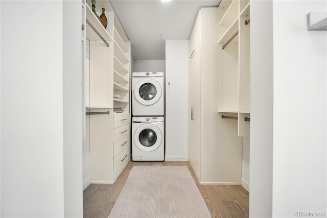 1898 S Bannock St Unit 202, Denver, CO 80223 - washroom featuring stacked washer and clothes dryer, light wood-type flooring, and baseboards