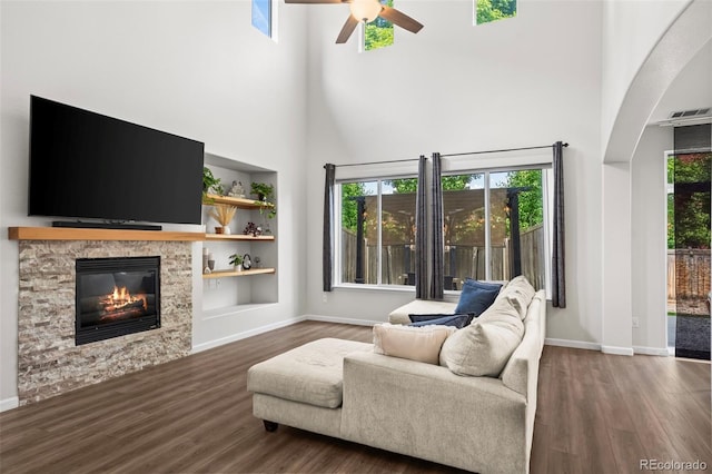 4975 S Zephyr St, Littleton, CO 80123 - living room with a ceiling fan, a high ceiling, wood finished floors, a fireplace, and built in shelves