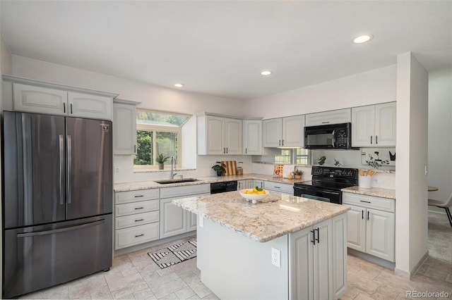 11797 W Aqueduct Dr, Littleton, CO 80127 - kitchen with black appliances, a center island, light stone countertops, and recessed lighting