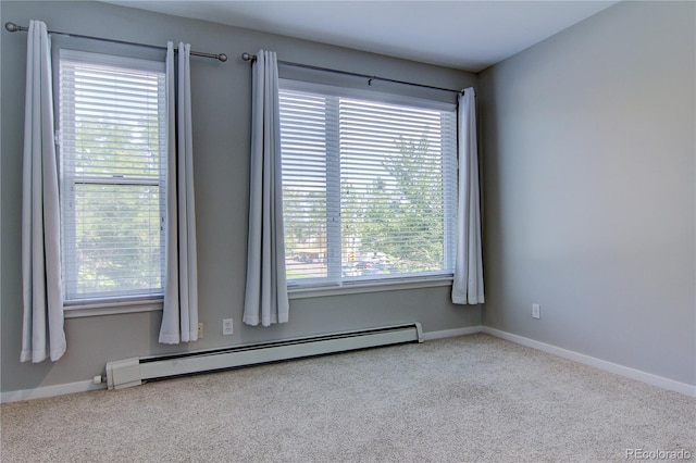 spare room featuring a baseboard radiator, light carpet, and a wealth of natural light