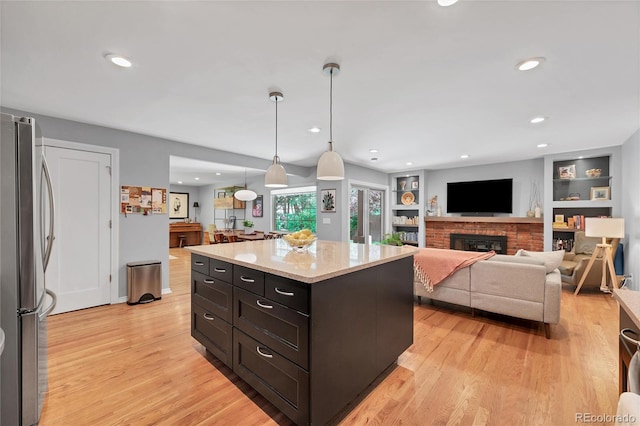 3196 S Newport St, Denver, CO 80224 - kitchen featuring freestanding refrigerator, light wood-style floors, pendant lighting, light stone countertops, and recessed lighting