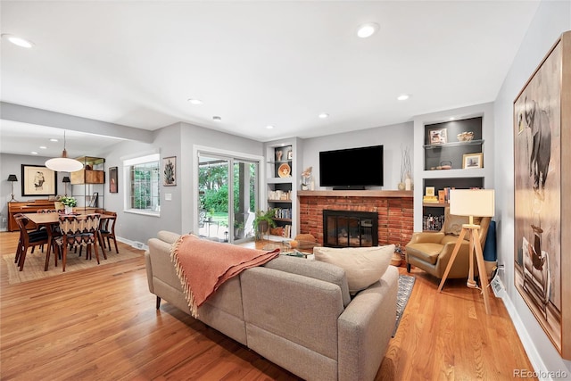 3196 S Newport St, Denver, CO 80224 - living room featuring a brick fireplace, light wood finished floors, built in features, and recessed lighting